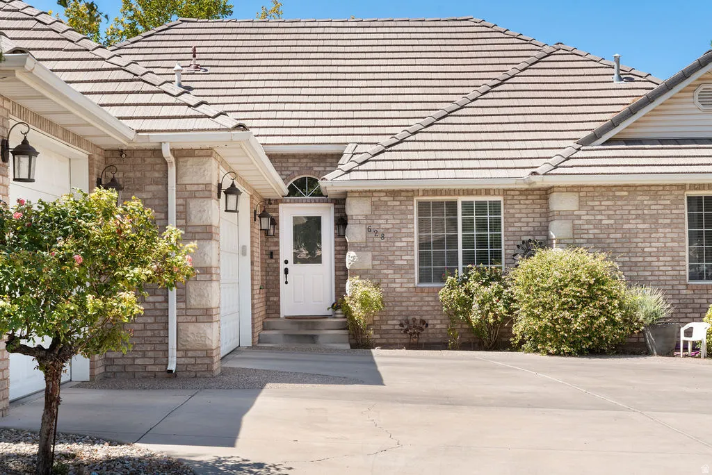 Brick exterior with stone accents, tile roofing, and a concrete driveway