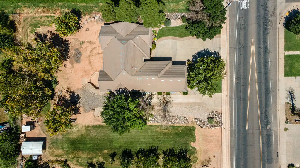 Expansive property featuring a multi-gabled roofline, concrete driveway, and a large grassy area