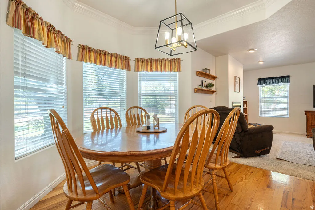 Bay window with blinds, wood-finish flooring, recessed lighting, and a geometric light fixture