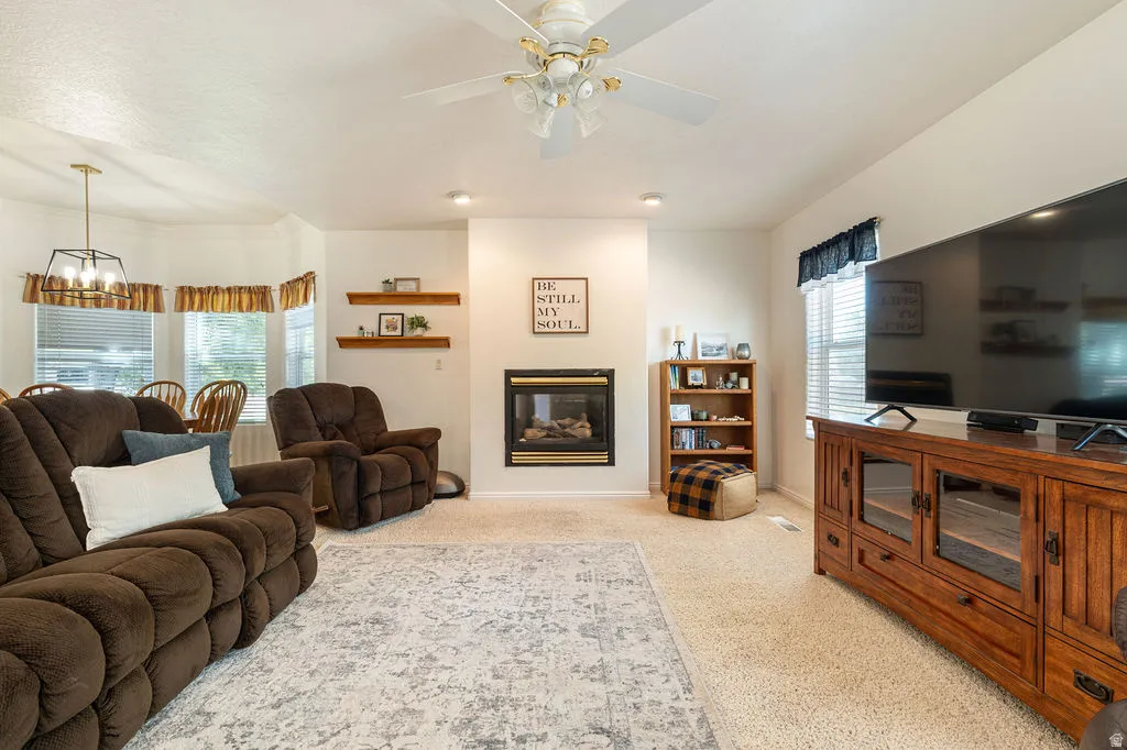 Carpeted living area with a built-in fireplace, recessed lighting, and a ceiling fan