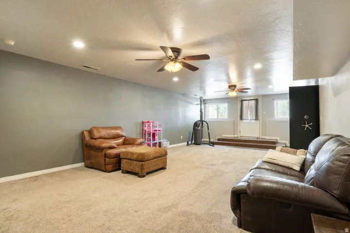 Recessed lighting, multiple ceiling fans, carpet flooring, a built-in safe, and a paneled white door