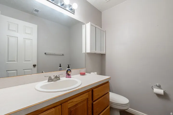 Vanity with a built-in sink, wood-finish cabinetry, and a full-width mirror