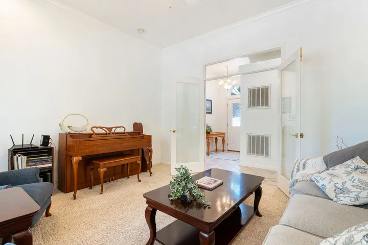 Double French doors, crown molding, and recessed lighting