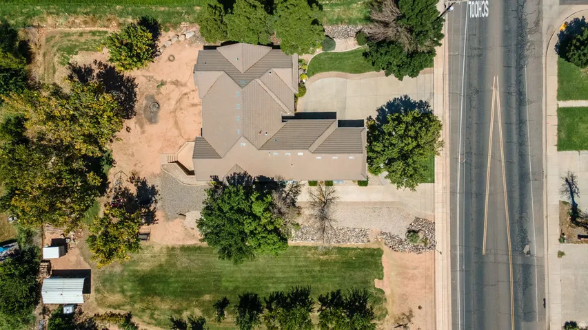Expansive property featuring a multi-gabled roofline, concrete driveway, and a large grassy area
