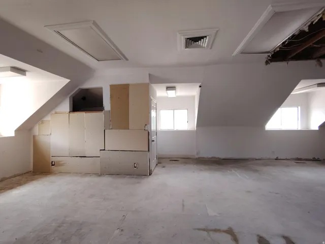 Sloped ceilings with multiple windows, recessed lighting, and built-in cabinetry