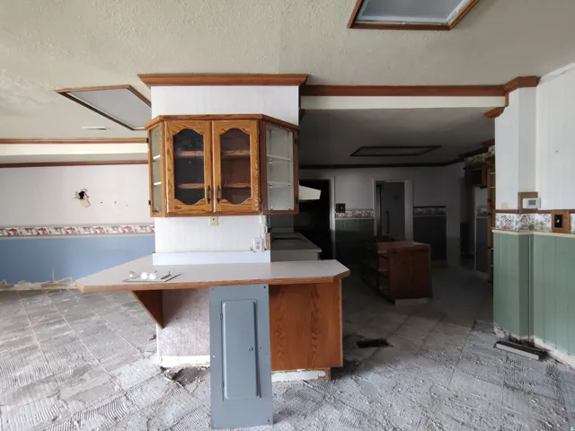 Kitchen with wood cabinetry, integrated breakfast bar, and multiple ceiling skylights