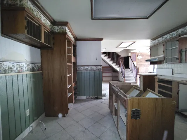 Built-in wood cabinetry and shelving, tile flooring, beadboard wainscoting, and a skylight