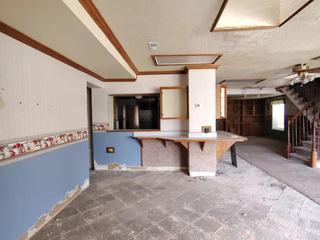 Built-in bar with wood-finish countertop, wood-finish trim, and recessed lighting