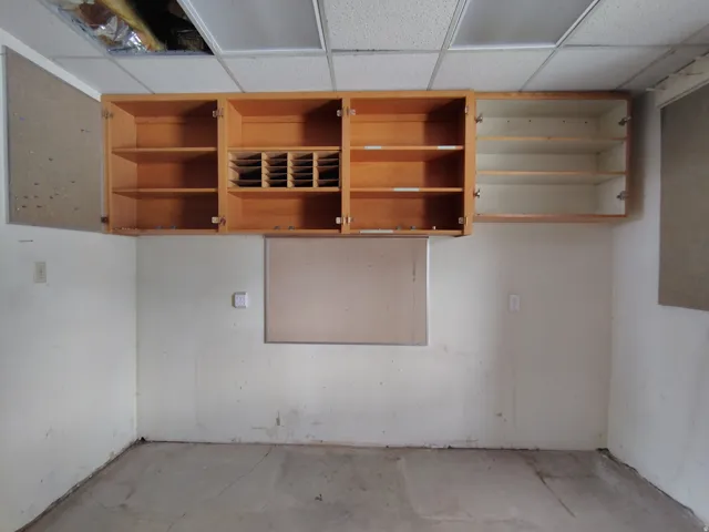 Wall-mounted wood cabinetry with integrated shelving and a built-in mail slot