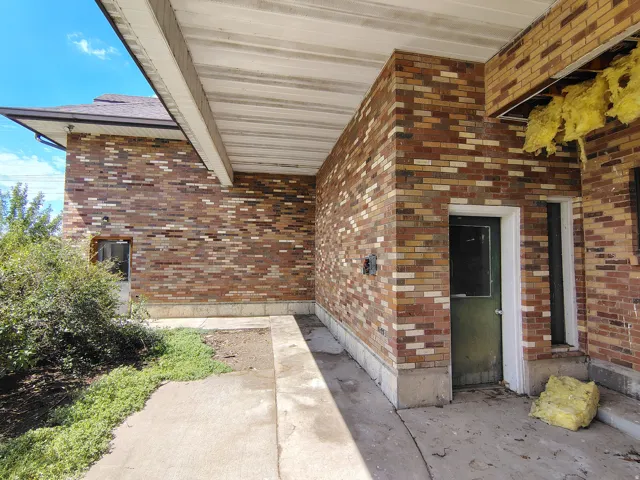 Brick exterior with a covered concrete walkway