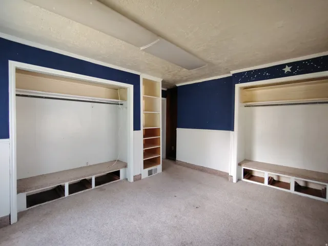 Two built-in wardrobe alcoves with integrated bench seating, built-in shelving, and carpet flooring