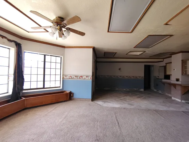 Wood-finish trim details, multiple large windows, and a ceiling fan with integrated lighting