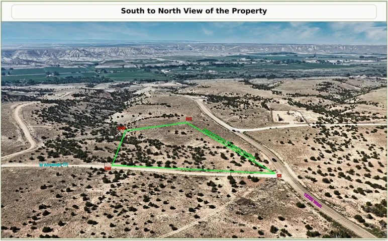 Expansive undeveloped land featuring natural terrain and distant green agricultural fields