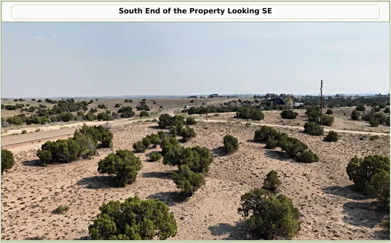 Expansive undeveloped land with natural vegetation and distant structures