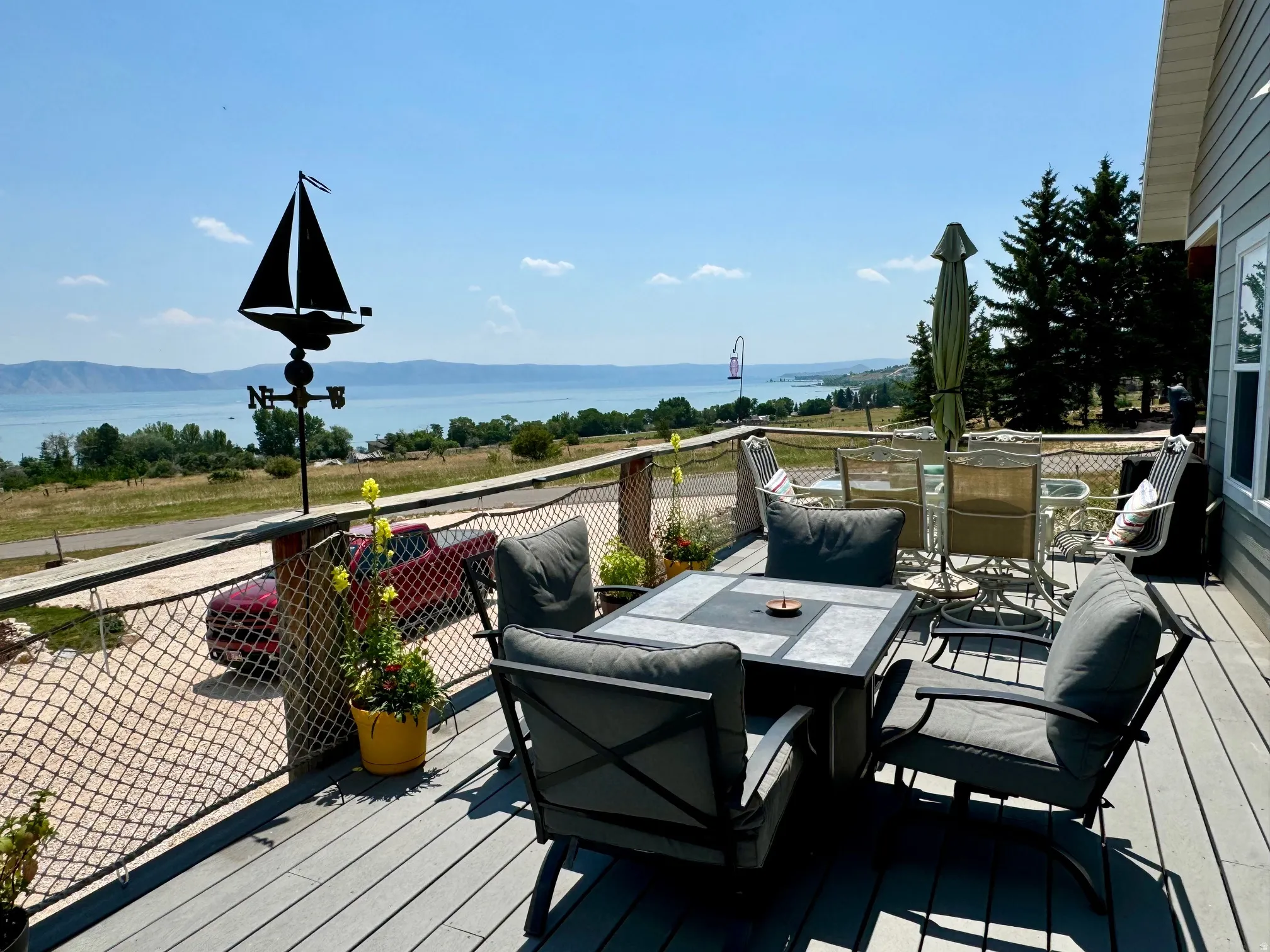 Expansive exterior deck with composite decking and cable railing, offering broad water scenery