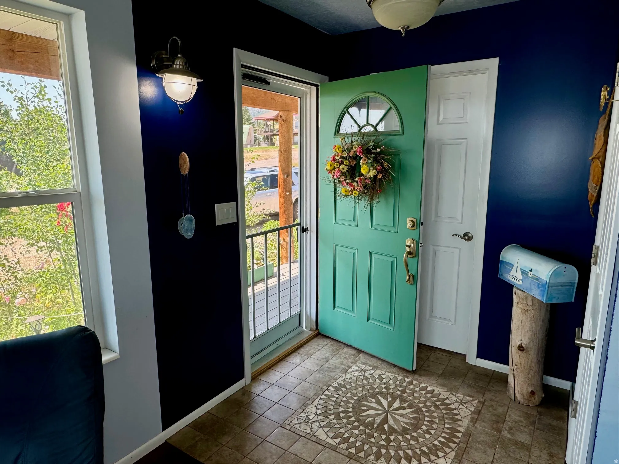 Entryway featuring a decorative front door, tile flooring, and a wall-mounted light fixture