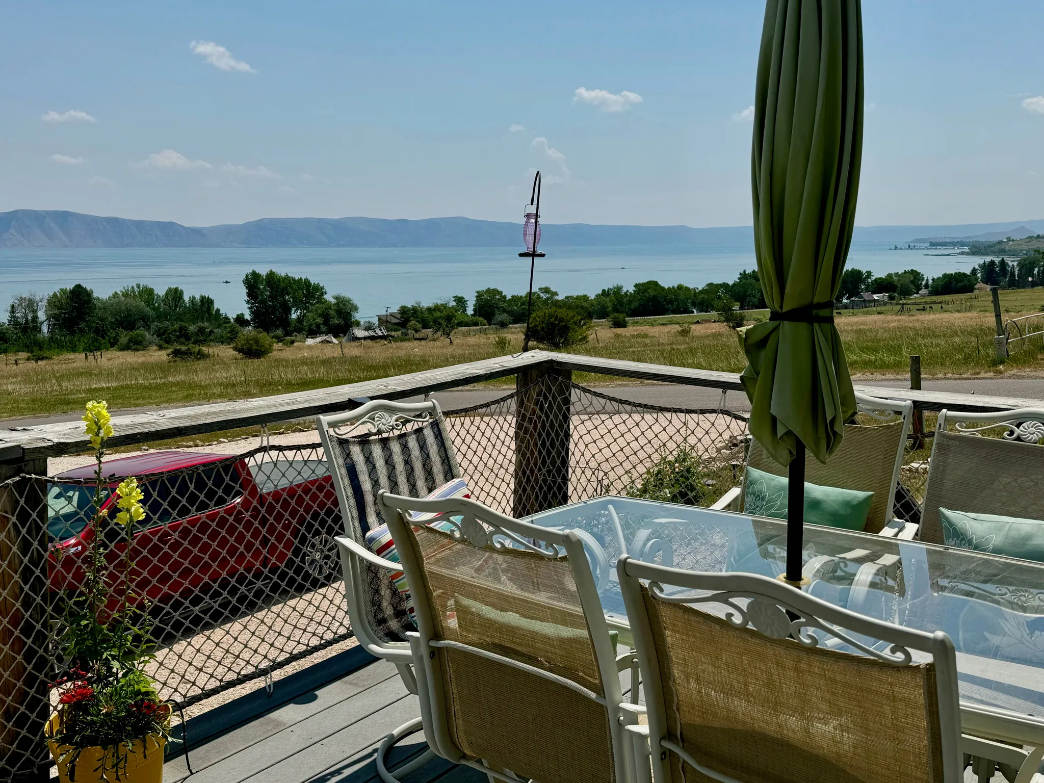 Deck with a decorative rope railing and a distant water body