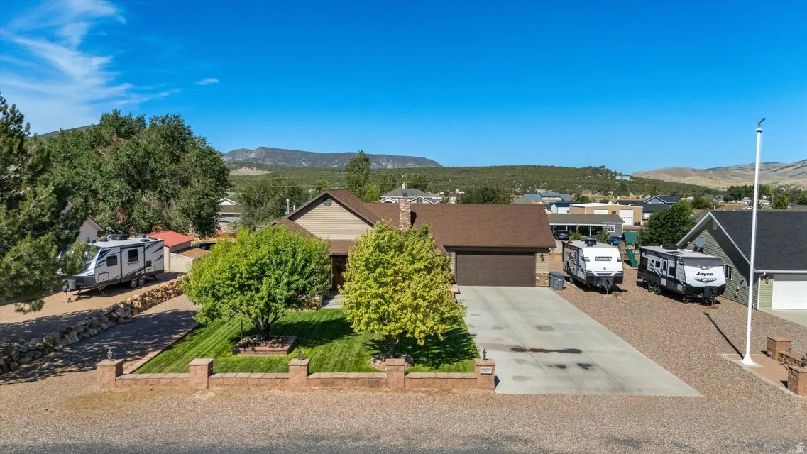 Single-story residence with an attached garage, concrete driveway, and gravel hardscaping