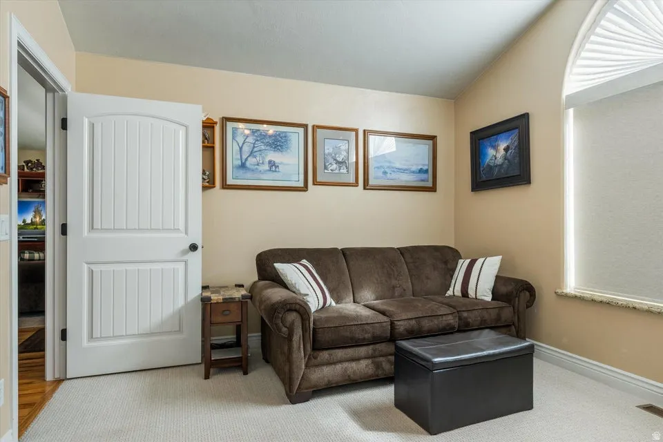 Vaulted ceiling accentuates the room, complemented by a white arched window with a pleated shade