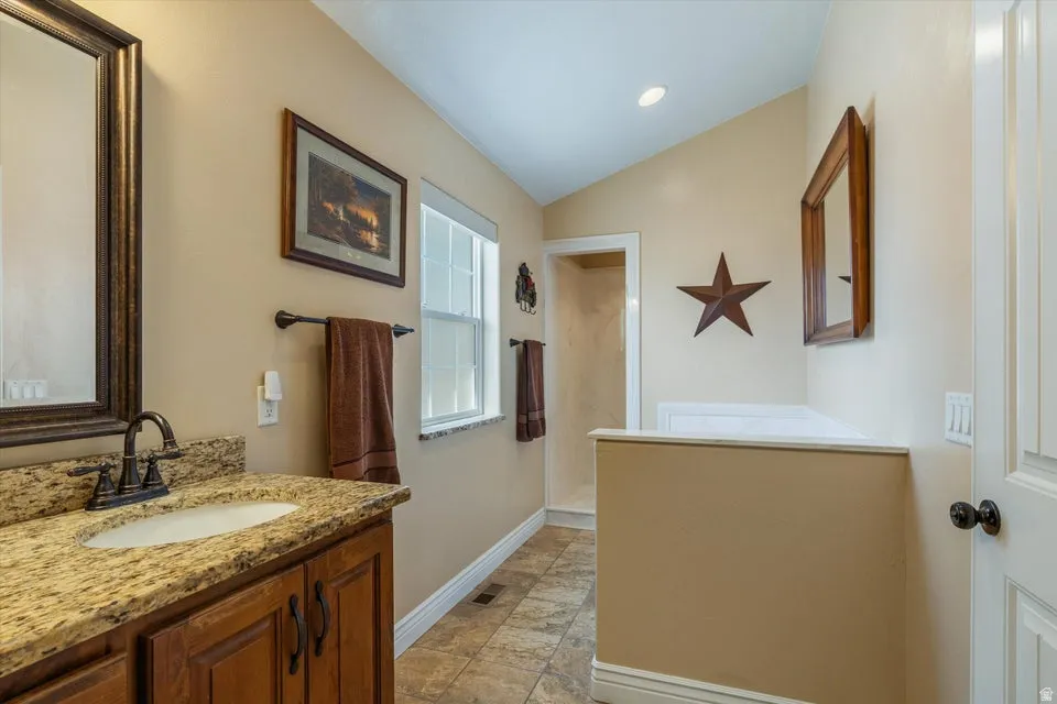 Vanity with a granite countertop, undermount sink, and dark bronze-finish faucet