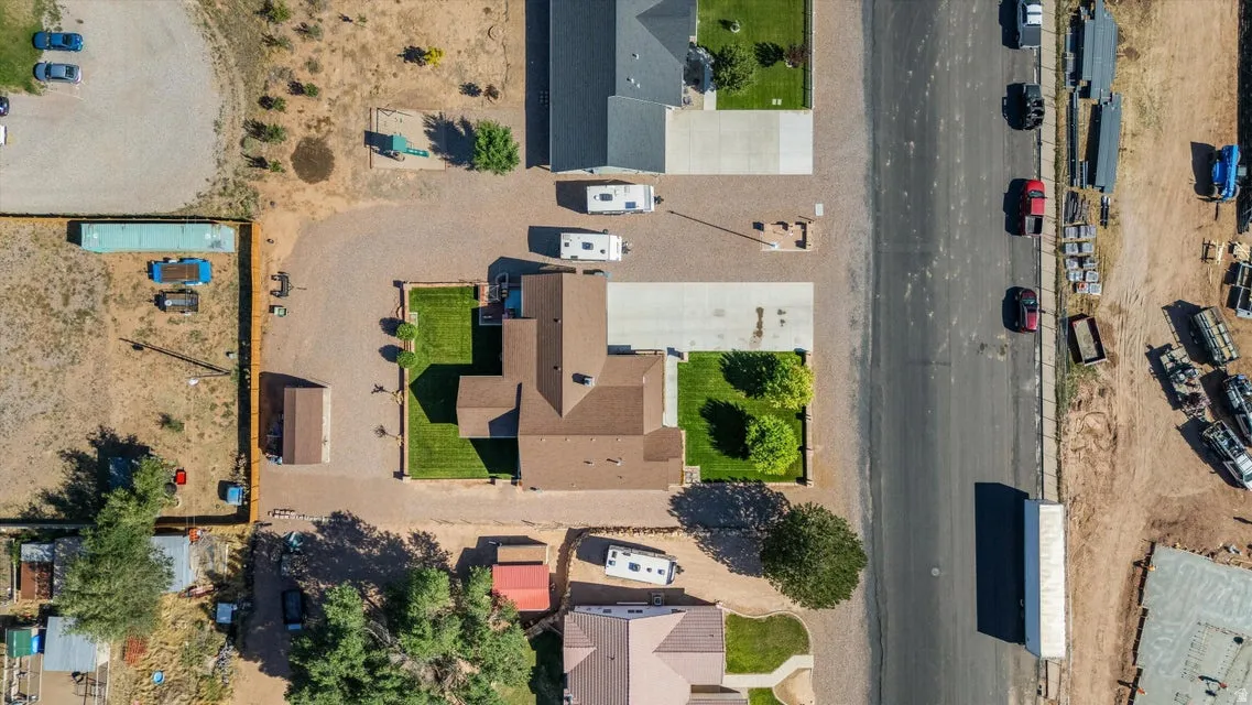 Residential property with brown roofing, concrete driveway, and green lawn areas