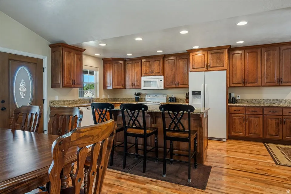 Kitchen featuring wood-finish flooring, recessed lighting, and a kitchen island with seating