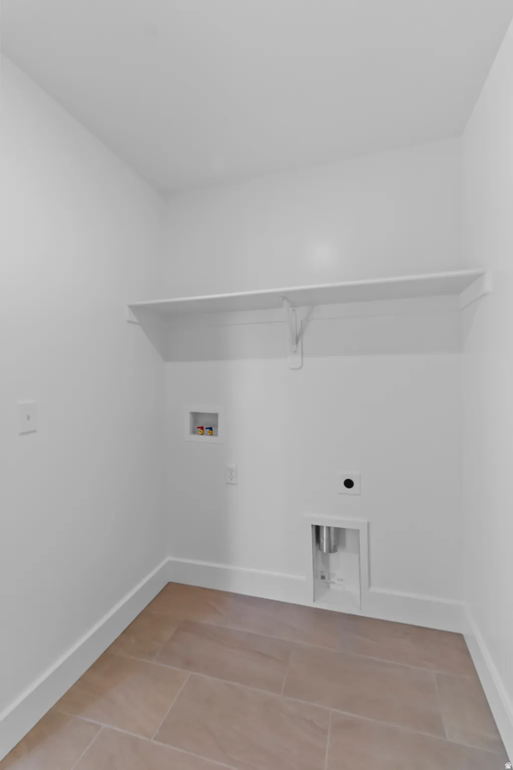 White walls with a built-in shelf, and tile flooring