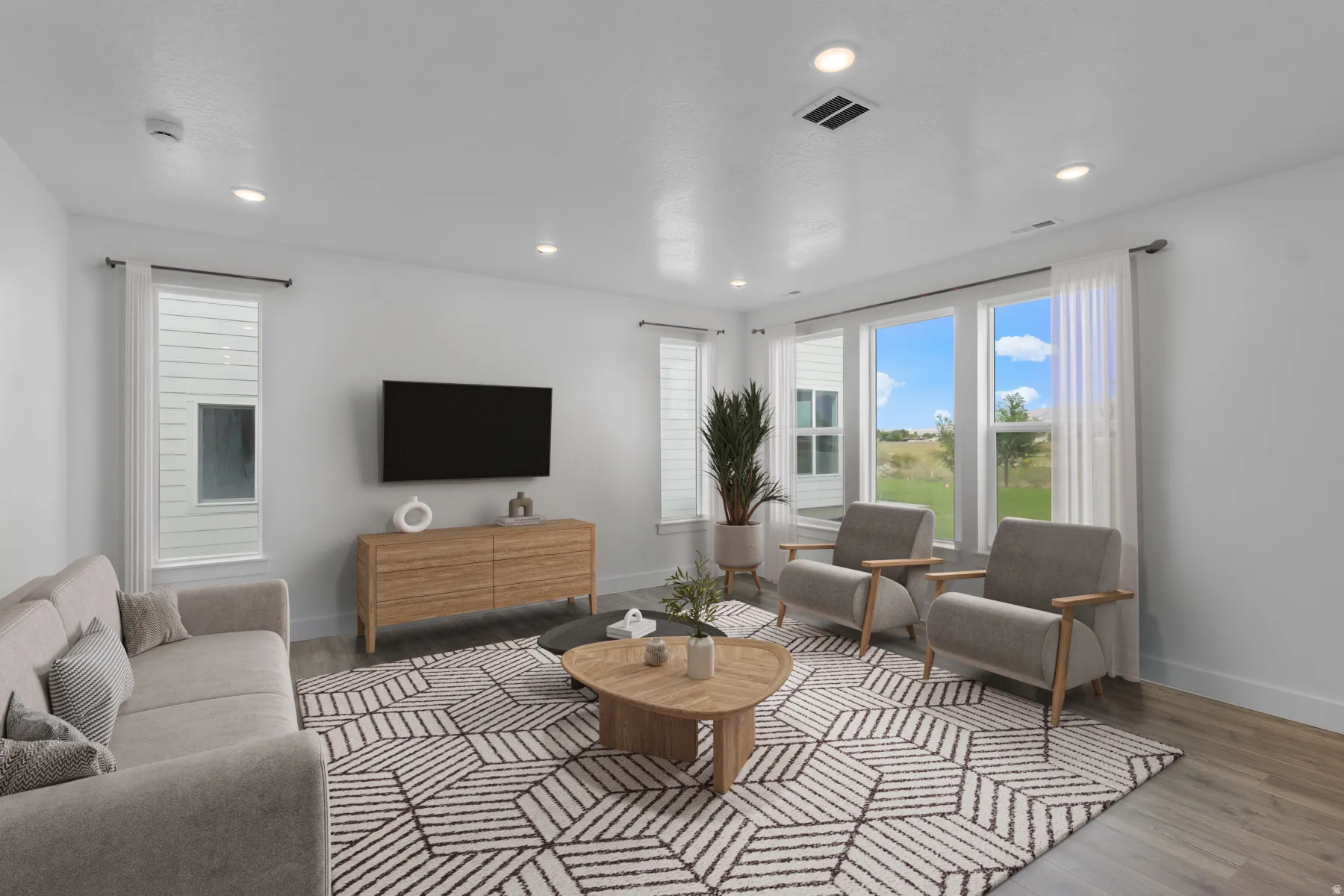 Recessed ceiling lighting, wood-finish flooring, multiple windows with roller shades, and a clean white wall finish