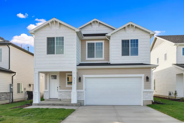 Two-story exterior with a covered entry, attached two-car garage, and a concrete driveway
