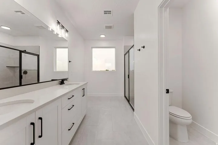 Dual vanity with undermount sinks, stone countertops, and matte black hardware