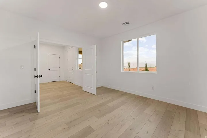 Wood-finish flooring, white walls, recessed lighting, and a dual-pane window