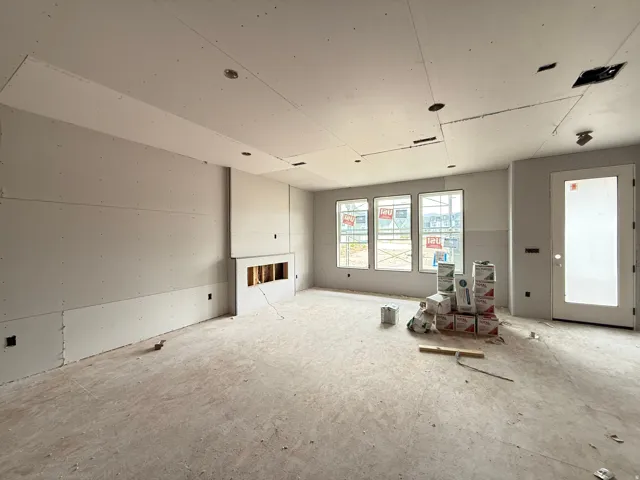 Triple window installation, built-in fireplace niche, recessed ceiling lighting, and a partially glazed door