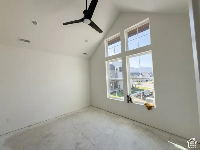 Vaulted ceilings, a contemporary ceiling fan, recessed lighting, and expansive multi-pane windows