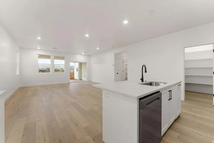 Open-concept living area with wood-finish flooring, recessed lighting, and a sliding glass door