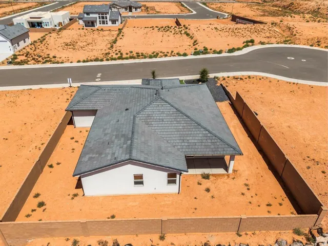 White exterior with dark tile roofing, two-car garage, and an enclosed rear patio