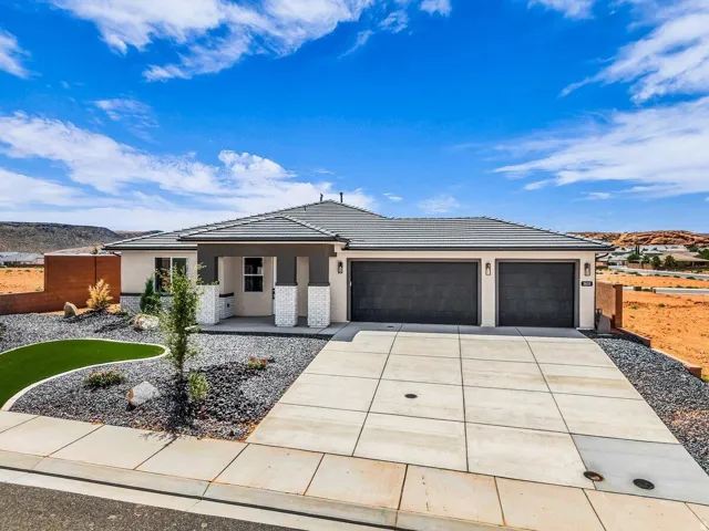 Contemporary exterior with a covered entry, stacked stone accents, a two-car garage, and a concrete driveway