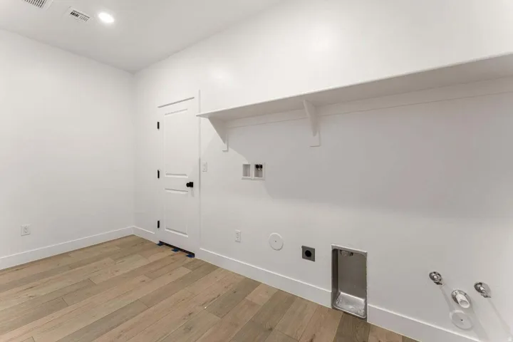 Laundry area featuring wood-finish flooring, recessed lighting, and a built-in shelf