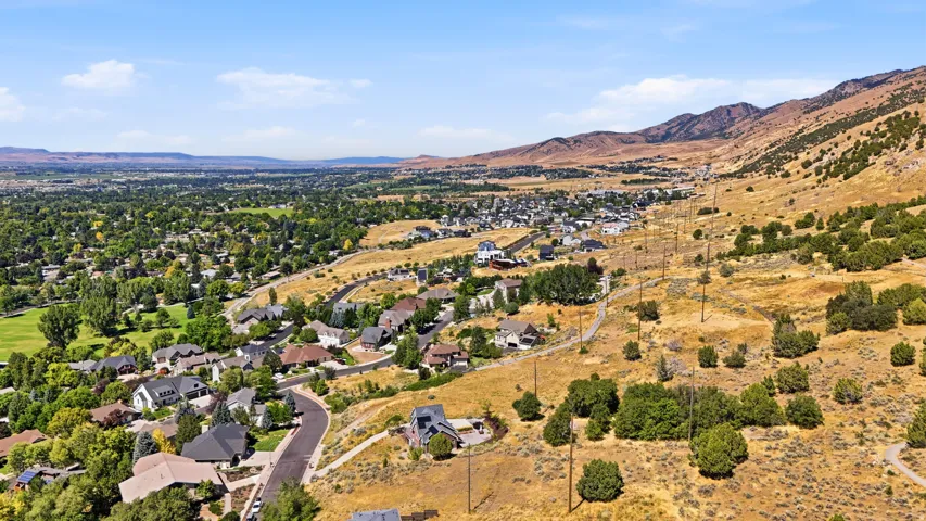 Expansive valley with residential areas, a golf course, and mountainous terrain