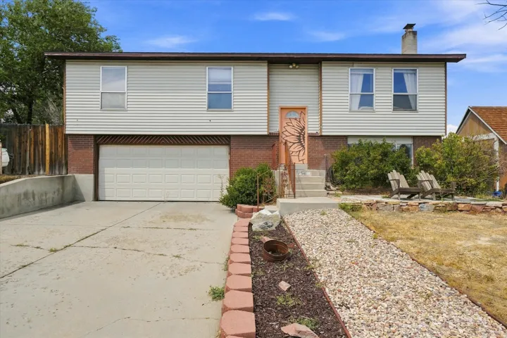 Split-level residence featuring brick and siding facade, an attached garage, and a concrete driveway
