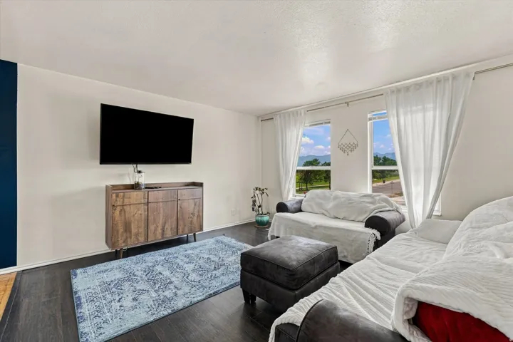 Large windows offering scenic mountain and landscape views, dark wood-finish flooring.