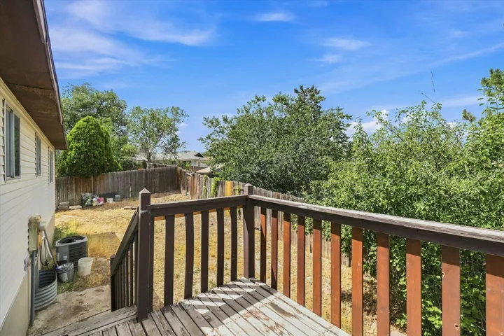 Wooden deck with a railing and steps leading to a fenced backyard