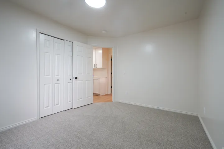 Neutral-toned carpeting, white walls, and a recessed ceiling light