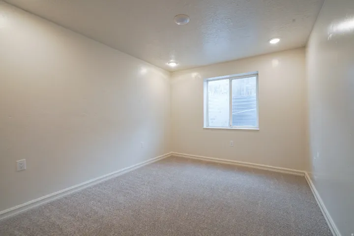 Recessed lighting, light-toned walls, and grey carpeting