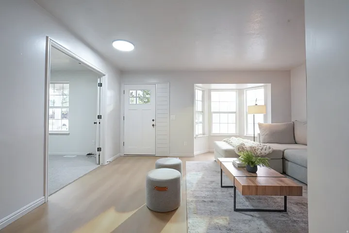 Entryway featuring wood-finish flooring, a white paneled door with glass inserts, and a round skylight
