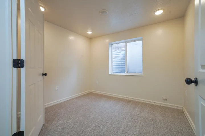 Neutral wall tones, recessed lighting, and carpeted flooring