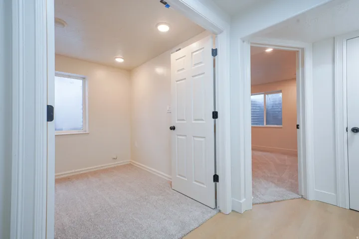 Recessed lighting, light-toned carpet, a paneled door, and a window with blinds