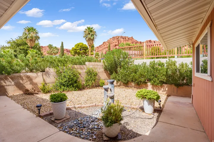 Landscaped courtyard featuring a multi-tiered water feature, gravel and river rock beds, and mature shrubs