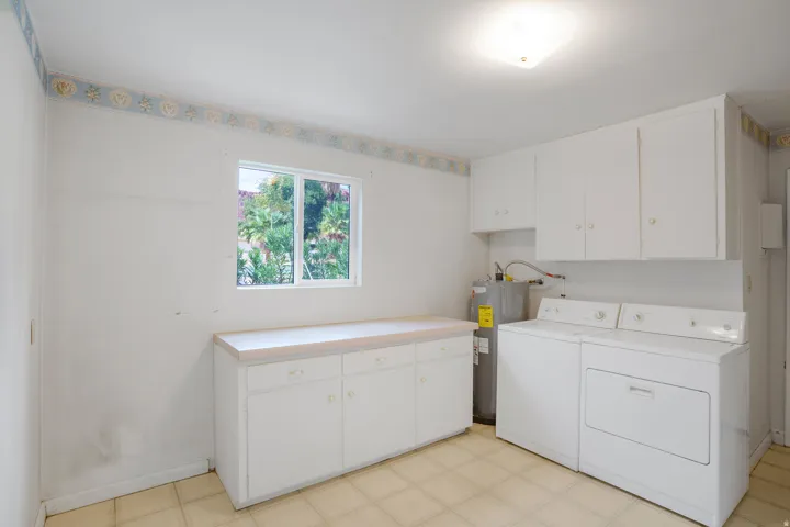 White cabinetry, light-toned countertop, and a window providing natural illumination