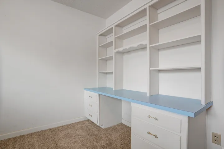 Built-in desk with a light blue countertop, custom shelving, and integrated drawers