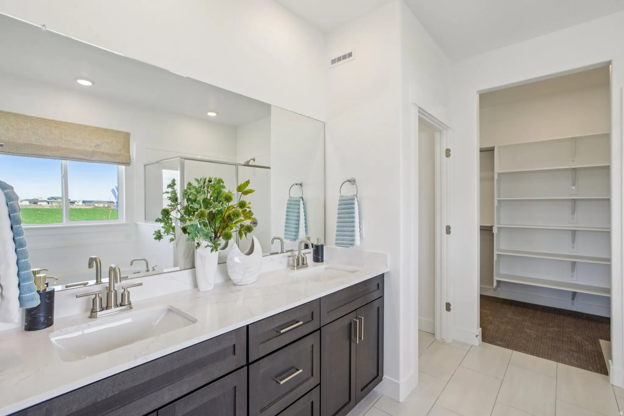 Dual vanity with undermount sinks, stone-finish countertop, and brushed nickel fixtures